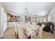 Open-concept dining area flowing into the kitchen and living spaces, featuring a modern chandelier at 10601 India Hawthorn Ave, Las Vegas, NV 89144