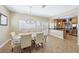 Cozy dining area with chandelier, large windows, and tile flooring, adjacent to the kitchen at 10601 India Hawthorn Ave, Las Vegas, NV 89144