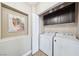 Laundry area featuring a washer, dryer, dark cabinetry and decorative artwork at 10601 India Hawthorn Ave, Las Vegas, NV 89144