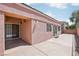 Large back patio with a stone perimeter, sliding glass doors and exterior sconces at 10601 India Hawthorn Ave, Las Vegas, NV 89144