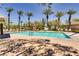 Community pool surrounded by lounge chairs and palm trees, perfect for relaxation and enjoyment at 10601 India Hawthorn Ave, Las Vegas, NV 89144