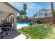 Inviting backyard with a covered patio, grill, manicured lawn, and a private pool at 11219 Castellane Dr, Las Vegas, NV 89141