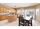 Sunlit kitchen features wooden cabinets, an island, a dining area, and a sliding door with a pool view at 11219 Castellane Dr, Las Vegas, NV 89141