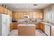Kitchen with wooden cabinets, light countertops, a center island, and stainless appliances at 11219 Castellane Dr, Las Vegas, NV 89141