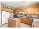 Bright kitchen featuring wooden cabinets, a kitchen island and updated appliances, providing ample storage and counter space at 11219 Castellane Dr, Las Vegas, NV 89141