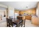 Well-lit kitchen area with wooden cabinets, an island, a dining table and access to the main entryway of the house at 11219 Castellane Dr, Las Vegas, NV 89141