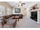 Cozy living room features a large sectional sofa, fireplace, neutral carpet, and plantation shutters at 11219 Castellane Dr, Las Vegas, NV 89141