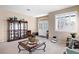 Bright living room featuring a glass display cabinet, a decorative coffee table, and a welcoming front entrance at 11219 Castellane Dr, Las Vegas, NV 89141