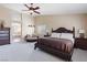 This is a spacious bedroom with an ornate dark wood bed, sitting area and ceiling fan at 11219 Castellane Dr, Las Vegas, NV 89141