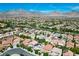 An aerial view shows the property's neighborhood and the distant mountains of Las Vegas under a clear blue sky at 11618 Costa Linda Ave, Las Vegas, NV 89138