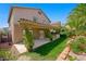 Back of home featuring a covered patio, lush landscaping, and a well manicured lawn at 11618 Costa Linda Ave, Las Vegas, NV 89138