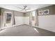Bedroom with wainscoting, plush carpet, and a ceiling fan, creating a comfortable and inviting space at 11618 Costa Linda Ave, Las Vegas, NV 89138