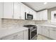 Well-equipped kitchen featuring white cabinets, a stainless steel oven and microwave, and ample counter space at 11618 Costa Linda Ave, Las Vegas, NV 89138
