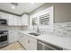 Bright kitchen features stainless steel appliances, a mosaic backsplash and white cabinets at 11618 Costa Linda Ave, Las Vegas, NV 89138