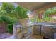 Outdoor kitchen area with high-end stainless steel grill, stone surround, and convenient storage at 11618 Costa Linda Ave, Las Vegas, NV 89138