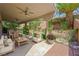 Inviting covered patio with comfortable seating, a ceiling fan, and a lush garden backdrop at 11618 Costa Linda Ave, Las Vegas, NV 89138