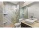 Modern bathroom with glass-enclosed shower, marble tile, and updated fixtures at 11784 Golden Moments Ave, Las Vegas, NV 89138
