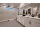 Modern bathroom featuring dual sinks, quartz counters, and walk-in shower with patterned tile flooring at 12053 Arrebol Ave, Las Vegas, NV 89138