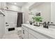Well-lit bathroom with dual sinks, tub-shower combo, and classic white and black accents at 12053 Arrebol Ave, Las Vegas, NV 89138
