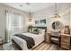 Bright bedroom featuring a comfortable bed, side table desk, stylish pendants, and neutral decor at 12053 Arrebol Ave, Las Vegas, NV 89138