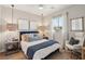 Well-lit bedroom featuring a comfortable bed, side table desk, stylish pendants, and neutral decor at 12053 Arrebol Ave, Las Vegas, NV 89138