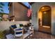 Inviting front porch with stylish outdoor furniture and an American flag, perfect for relaxing outdoors at 12053 Arrebol Ave, Las Vegas, NV 89138