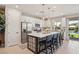 Modern kitchen with island, seating, stainless steel appliances, and view to backyard at 12053 Arrebol Ave, Las Vegas, NV 89138