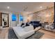 Serene primary bedroom with a brick accent wall, hardwood floors, and modern furnishings at 12053 Arrebol Ave, Las Vegas, NV 89138