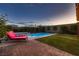 Relaxing backyard with a pool, spa, lounge chairs, green grass, and privacy wall at 12053 Arrebol Ave, Las Vegas, NV 89138