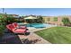 Lush backyard showcasing a pool, spa, lounge chairs, and a well-manicured lawn at 12053 Arrebol Ave, Las Vegas, NV 89138