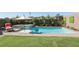 Bright backyard featuring a sparkling pool, integrated spa, and a lush green lawn at 12053 Arrebol Ave, Las Vegas, NV 89138