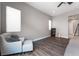 This bedroom features an accent chair, wood flooring, and a window with natural light at 12843 New Providence St, Las Vegas, NV 89141