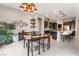 Open-concept dining area adjacent to kitchen with stylish chandelier and tile flooring at 12843 New Providence St, Las Vegas, NV 89141