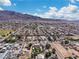 An aerial view showcasing a residential neighborhood, set against a backdrop of majestic mountains and clear skies at 131 Beesley Dr, Las Vegas, NV 89110