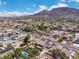 Overhead view of a community near mountains, emphasizing a home with a lush backyard and pool at 131 Beesley Dr, Las Vegas, NV 89110