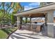 Inviting outdoor kitchen featuring a covered area with a countertop bar and lush landscaping at 131 Beesley Dr, Las Vegas, NV 89110
