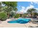 Lush backyard oasis with a sparkling pool, hot tub, and shaded lounge areas surrounded by palm trees at 131 Beesley Dr, Las Vegas, NV 89110