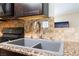Kitchen featuring a stainless faucet and gray double-basin sink set in a granite countertop at 1615 Palora Ave, Las Vegas, NV 89169