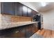 Features granite countertops, dark cabinets, tile backsplash, and stainless steel refrigerator at 1615 Palora Ave, Las Vegas, NV 89169