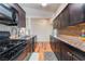 Kitchen featuring gas range, granite counters, and dark wood cabinets with a tile backsplash at 1615 Palora Ave, Las Vegas, NV 89169