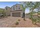 Two-story home with a brick driveway, desert landscaping, and a two-car garage at 169 Volti Subito Way, Henderson, NV 89011