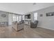 Comfortable living room featuring wood-look tile floors and sliding door access to patio at 169 Volti Subito Way, Henderson, NV 89011
