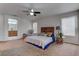 Spacious bedroom featuring a ceiling fan, stylish decor, and natural light from large windows at 214 Bella Matese Ave, Las Vegas, NV 89183