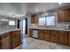Well-lit kitchen with wooden cabinets, tile floors, stainless steel dishwasher and silver backsplash at 214 Bella Matese Ave, Las Vegas, NV 89183
