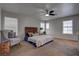 Bedroom featuring a woven headboard, ceiling fan, plush carpet, and ample natural light from dual windows at 214 Bella Matese Ave, Las Vegas, NV 89183