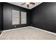 Cozy bedroom with a ceiling fan, two windows, plush carpet and stylish dark-colored walls at 2205 Beacon Ridge Dr, Las Vegas, NV 89134