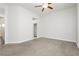 Large bedroom with neutral carpet, ceiling fan, light walls, and access to closets and bathroom at 2205 Beacon Ridge Dr, Las Vegas, NV 89134