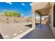 Covered patio and desert landscaping offer a relaxing outdoor living space with mature trees and plants at 2205 Beacon Ridge Dr, Las Vegas, NV 89134