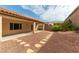 Landscaped backyard with stone path leading to covered patio and privacy wall at 2357 Aztec Ruin Way, Henderson, NV 89044