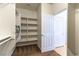 Walk-in closet with custom shelving and plush carpet floors at 2357 Aztec Ruin Way, Henderson, NV 89044